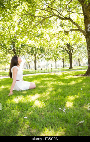 Side view of woman sitting on grassland Stock Photo