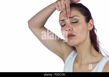 Beautiful woman with eyes closed white touching forehead Stock Photo