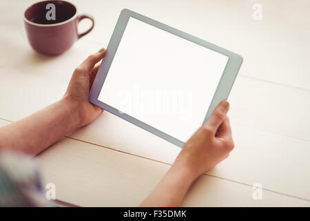 Hands holding digital tablet by coffee cup Stock Photo