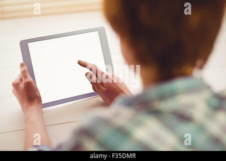 Hands holding digital tablet by coffee cup on table Stock Photo