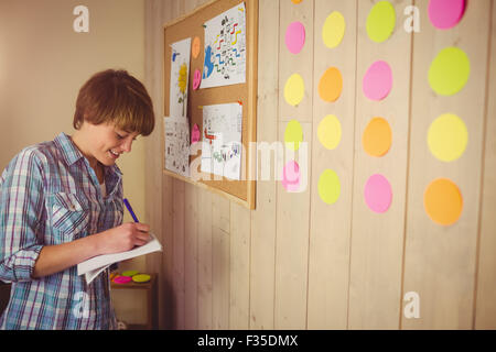 Smiling young woman taking notes Stock Photo