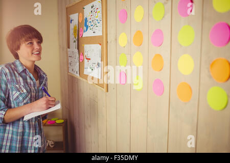 Smiling young woman taking notes Stock Photo