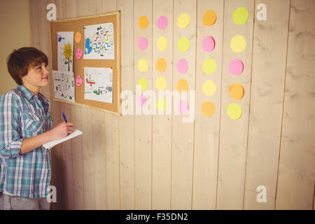 Smiling young woman taking notes Stock Photo