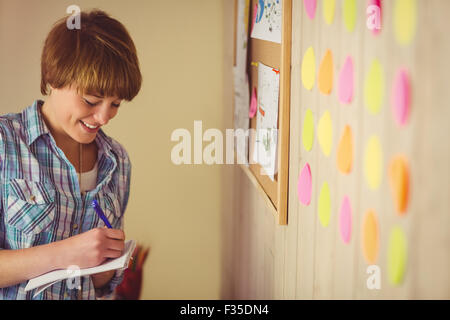 Smiling young woman taking notes Stock Photo
