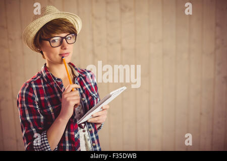 Pretty thoughtful young woman holding pen Stock Photo