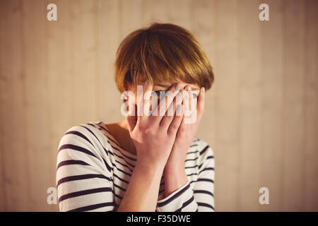 Pretty short hair woman hiding her face behind her hands Stock Photo