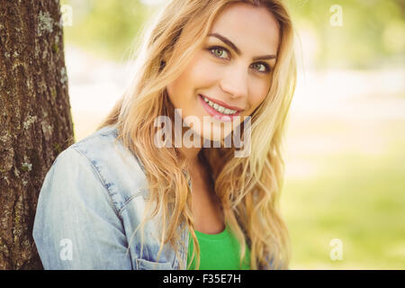 Portrait of smiling woman sitting under tree Stock Photo