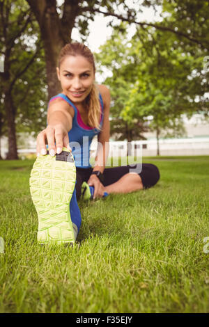 Portrait of smiling woman stretching leg Stock Photo