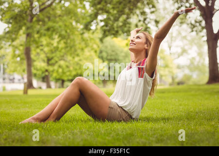 Full length of happy woman with hands raised on grass Stock Photo