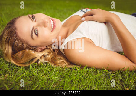 Side view of smiling woman lying on grass Stock Photo