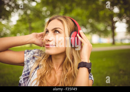 Smiling woman enjoying music at park Stock Photo