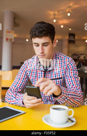 Young man using mobile phone in cafe Stock Photo