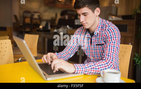 Young man using laptop on table Stock Photo
