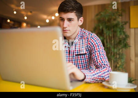 Concentrated young man using laptop Stock Photo