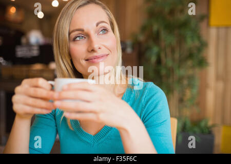 Thoughtful young woman holding coffee cup Stock Photo