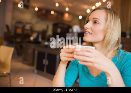 Young woman holding coffee cup looking away Stock Photo