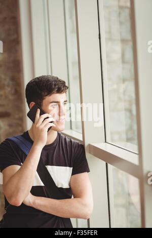 Male student talking on mobile phone in college Stock Photo