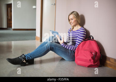 Female student smiling while using digital tablet Stock Photo