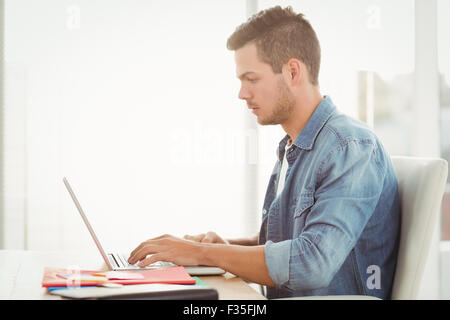 Side view of young man working on laptop Stock Photo