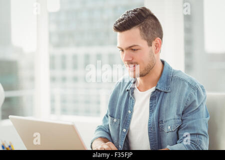 Smiling young man working on laptop Stock Photo