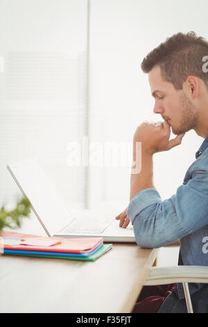 Thoughtful young man using laptop Stock Photo