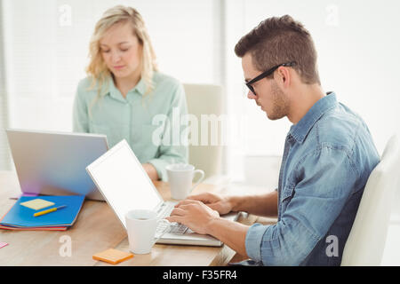 Serious man and woman working on laptop Stock Photo