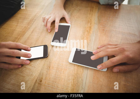 Cropped hands touching smartphones at office Stock Photo