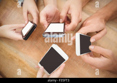 Overhead view of cropped hands using smartphones Stock Photo