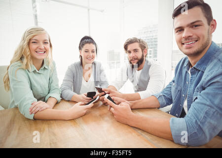 Portrait of smiling business people using smartphones Stock Photo