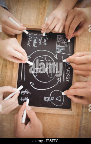 Overhead view of cropped hands writing business terms on slate Stock Photo
