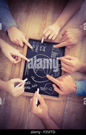 Close-up of cropped hands writing business terms on slate Stock Photo