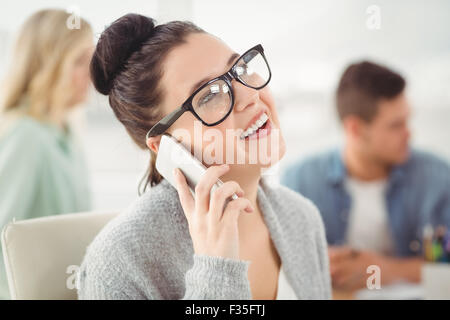 Happy woman wearing eyeglasses talking on smartphone Stock Photo