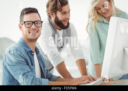 Portrait of smiling man at computer desk Stock Photo