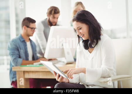 Happy woman with headphones using digital tablet Stock Photo