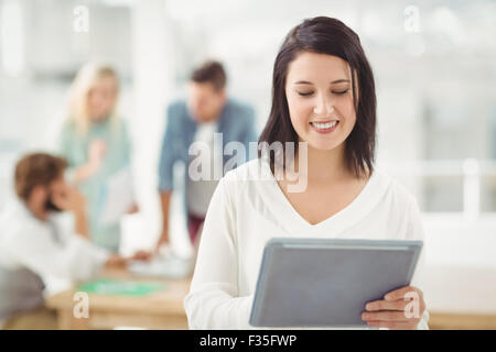 Smiling woman using digital tablet Stock Photo
