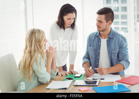 Business professionals discussing at desk Stock Photo