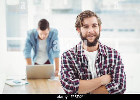 Portrait of smiling businessman standing with arms crossed Stock Photo