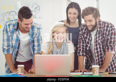 Smiling colleagues working on laptop Stock Photo
