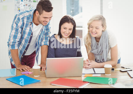Happy colleagues working on laptop Stock Photo