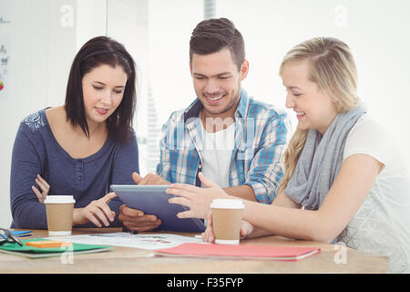 Smiling colleagues working using digital tablet Stock Photo