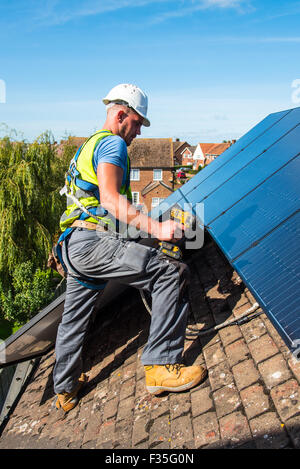 Roofer fitting a domestic solar panel system Stock Photo