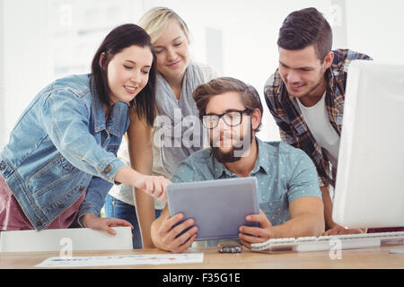 Business people using digital tablet while sitting at computer desk Stock Photo