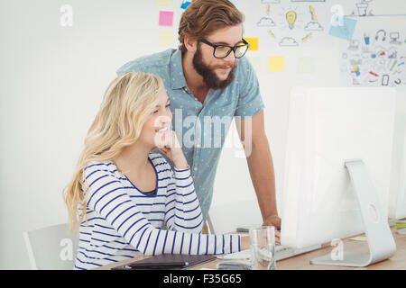 Smiling business people looking at computer Stock Photo