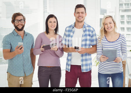 Portrait of smiling business people using electronic gadgets Stock Photo