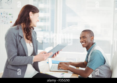Smiling businesswoman discussing with man Stock Photo