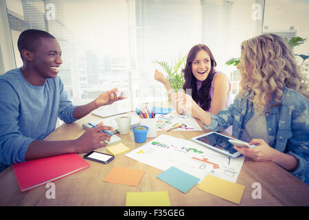 Happy business people working at desk in creative office Stock Photo