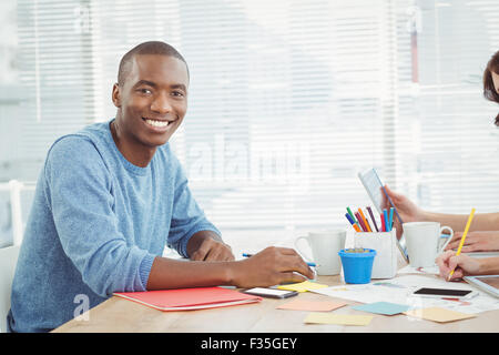 Portrait of smiling man while working at desk Stock Photo