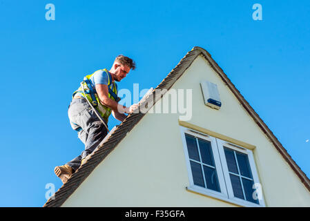 Roofer fitting supporting rail for a domestic solar panel system. Stock Photo