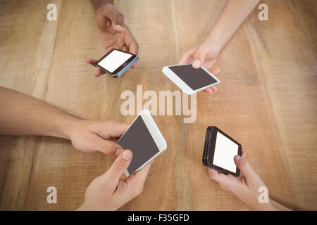 Close-up of cropped hands using mobile phones at desk Stock Photo