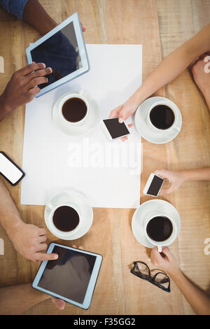 Close-up of people using technology at desk Stock Photo